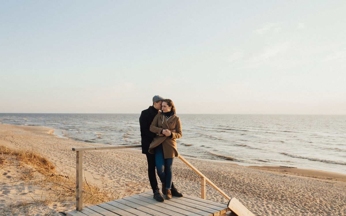Casal abraçado à beira-mar durante uma viagem